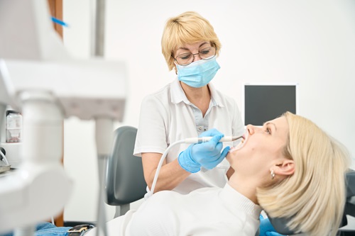Caucasian woman doctor treats her patient's teeth
