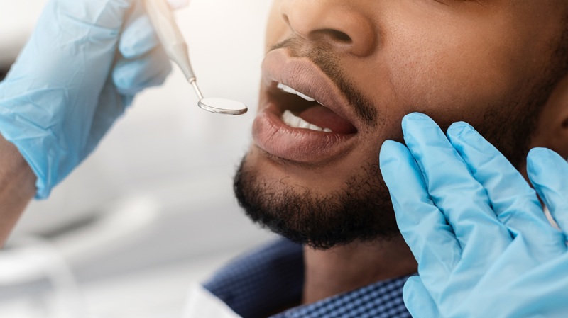 dentist checking dry mouth of a man patient
