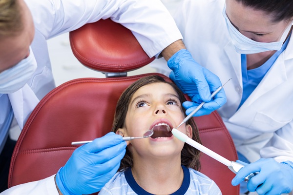 Attentive dentists examining young patient in dental clinic
