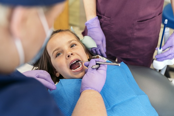 Cute little girl during revision at the dentist. She has her mouth open.